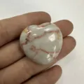 Herzförmiges Naturstein-Ornament mit rötlichen Adern in einer Nahaufnahme der Hand - Herz / 20x6mm / Roter Netzwerkstein