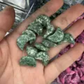 Kleine groene maanvormige natuurstenen houtsnijwerk in een handpalm voor display. - 20x6mm / Groene puntsteen