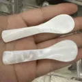 Vista detallada de dos cucharas de nácar blanco natural para mascarillas y café - Aprox. 73x20x3mm / Concha Blanca