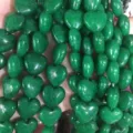 Gedetailleerde macro-opname van de natuurlijke textuur van groene hartvormige kralen - Maleisische Jade