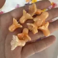 Top-down detail shot of peach-colored flower-shaped beads held in hand. - Two-tone Orange