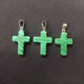 Detail shot of three malachite-patterned stone cross pendants with silver bails. - Malachite-toned Stone