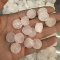 Detailansicht von 14mm doppelseitig geschnitzten weißen Quarz-Rosenperlen in der Hand - Rosenstil (0001) / 14mm / Weiß Kristall