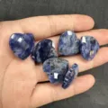 Nahaufnahme von facettierten blauen Naturstein-Herzanhängern in der Hand für DIY-Schmuck - Ca. 20*6mm / Blauer Sodalith