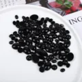 Macro view of polished black onyx cabochons in various shapes for jewelry making - Oval / 15x20mm