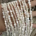 Nahaufnahme von weißen herzförmigen Süßwassermuschelperlen mit Perlmuttglanz für DIY-Schmuck. - Herzform mit horizontalem Loch / 约6mm(约63颗左右一条)