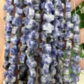 Detalle macro de cuentas de sodalita azul natural en forma de cruz para bisutería artesanal - 8x8x4mm (Aprox. 50 Piezas/Paquete) / Piedra de Puntos Azules
