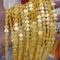 Close-up texture of yellow heart-shaped mother of pearl beads for DIY jewelry making. - Vertical Hole Heart Shape / 8mm (Approx 47 Beads per Strand) / Yellow