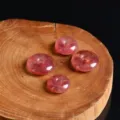Macro view of natural strawberry crystal ping'an kou beads on a wooden background - 15mm / Strawberry Quartz