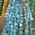 Detail view of colorful heart-shaped mother of pearl shell beads with iridescent luster finish - Horizontal Hole Heart Shape / 8mm (Approx 47 Beads per Strand) / Blue