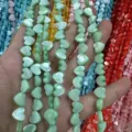 Close-up detail of heart-shaped green mother-of-pearl shell beads for DIY jewelry accessories - Horizontal Hole Heart Shape / 8mm (Approx 47 Beads per Strand) / Green