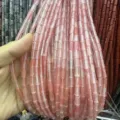 Close-up view of pink translucent 4x9mm tube-shaped natural stone beads for DIY jewelry - Rectangle Strip (Length 38cm) / Watermelon red