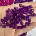 Primo piano di pietre preziose ovali sfaccettate viola per gioielli fai-da-te - Giada Viola Rosa (Trattata)