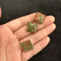 Nahaufnahme von drei polierten quadratischen Unakit-Naturstein-Cabochons für DIY-Schmuckherstellung - Unakit