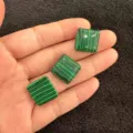 Nahaufnahme von drei quadratisch grün gestreiften Malachit-Cabochons für DIY-Schmuck - Pfauentürkis