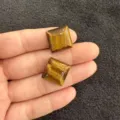 Detaillierte Makroansicht von zwei polierten quadratischen gelben Tigerauge-Steinen - 10mm / Tigerauge