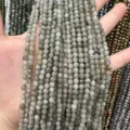 Gros plan de perles de pierre grise facettée naturelle en main - Perle Ronde Facettée Triangulaire / 4mm (Environ 90 Pièces/Fil) / Labradorite