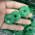 Close-up of 25mm green natural stone donut charms for DIY jewelry making accessories - Malaysian Jade