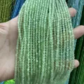 Detail of 3mm faceted light green cat eye stone beads held in hand for jewelry making - 3mm (Approx 120 Beads/Strand) / Pale Green