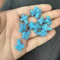 Close-up of small blue turquoise cross beads with black veins and vertical hole design - Approx 12*16mm / 1 Bead / Turquoise