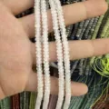 Nahaufnahme von 2x4 mm facettierten weißen Natursteinperlen für die Schmuckherstellung - 约2x4mm(约150颗一条) / Natürlicher weißer Kristall