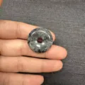 Handheld view of a 25mm natural gray marbled stone donut pendant for DIY jewelry making - Black Flash