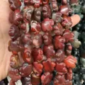 Detailed view of red natural stone flower shaped beads for DIY jewelry making crafts - 25 Pieces/Strand (15x15x5mm) / Red Jasper