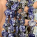 Macro detail of blue and white marbled stone plum blossom flower shaped beads for DIY crafts. - 25 Pieces/Strand (15x15x5mm) / Blue Spot Stone