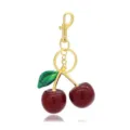 Goldfarbener Kirschen-Schlüsselanhänger mit glitzernden roten Beeren und grünem Blatt. - Stil 2