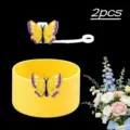 Dettaglio copribase in silicone per bicchiere e tappo per cannuccia con farfalla. - Giallo