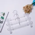 Cintre pantalon multicouche en plastique avec pinces pour le rangement de la garde-robe. - Transparent