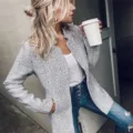 Detailed shot of a stylish grey herringbone tweed jacket worn by a model in street style. - S / Tops / Light Gray