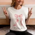 Detalle de cerca de camiseta blanca de mujer con lazo rosa y texto en francés estampado. - S / Lazo Rosa Blanco