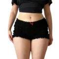 Vista detallada de pantalones cortos negros de tiro bajo con volantes y lazo rojo. - S / Negro