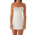 Close-up of white strapless mini dress featuring stunning 3D floral rose neckline details. - White