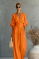 Gedetailleerd overzicht van de stijlvolle oranje jumpsuit met V-hals, getailleerd en wijde pijpen. - Oranje