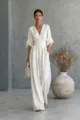 Elegante witte jumpsuit model scène met V-hals, getailleerde taille en breed beenontwerp. - S / Jumpsuits / Wit