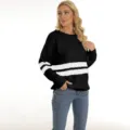 Detailed view of women black and white striped knit sweater pullover worn by female model. - Black