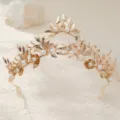 Detailaufnahme einer goldenen Brauttiara, die feine Metallblätter und elegante Perlen zeigt. - Gold