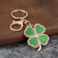 Golden four-leaf clover keychain with green glitter rhinestones elegant bag charm pendant - Body Glitter