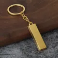 Detailed close-up of a miniature gold bar keychain, featuring engraved bullion design and ring. - No. 1