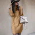 Detailaufnahme einer Frau in einem camelbraunen Rollkragen-Strickkleid mit Stiefeln und Tasche. - S / Oberteile / Khaki