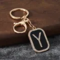Close-up detail of the gold metal rhinestone letter Y keychain pendant and clasp. - Letter Y
