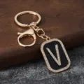 Gold metal rhinestone letter V keychain detail, stylish bag charm and car key ring accessory. - Letter V