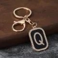 Detailed view of gold rhinestone letter Q keychain pendant, stylish metal car key accessory. - Letter Q