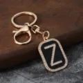 Detailed shot of gold metal letter Z rhinestone keychain pendant with black enamel finish. - Letter Z