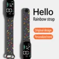 Primo piano dell'orologio sportivo elettronico nero con cinturino colorato a fantasia di coriandoli. - Nero