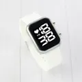 Detailed close-up of white LED digital watch featuring square silver case and silicone strap. - Silver Case White Dial
