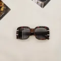 Square tortoise sunglasses detail shot with gold metal accents and UV protection lenses. - Mixed Tortoise Gray Lens