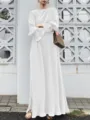 Detailed view of white pleated long dress fabric and elegant drape on model in outdoor setting. - White